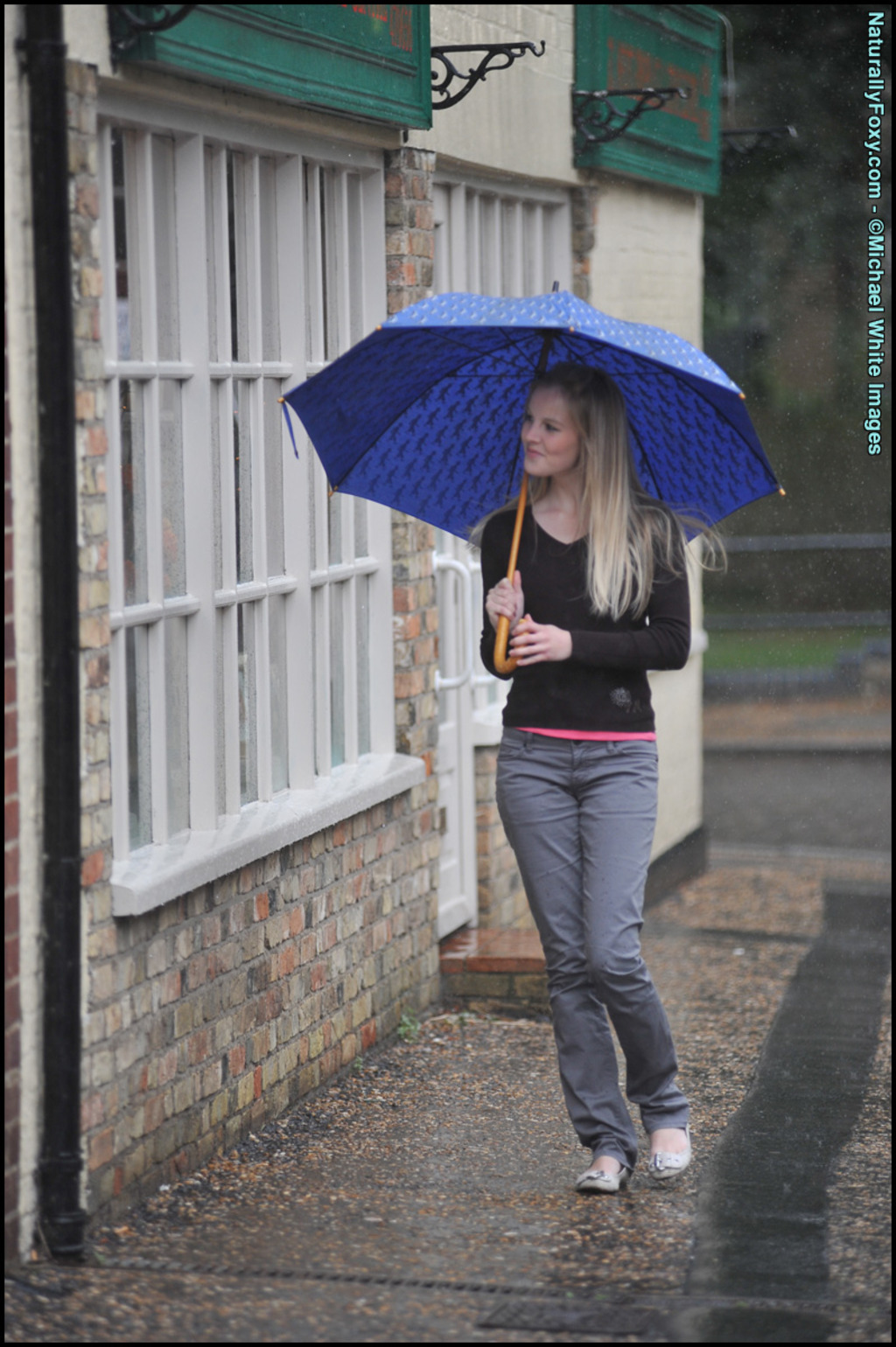 Blonde Girl Next-door Type Holds An Umbrella